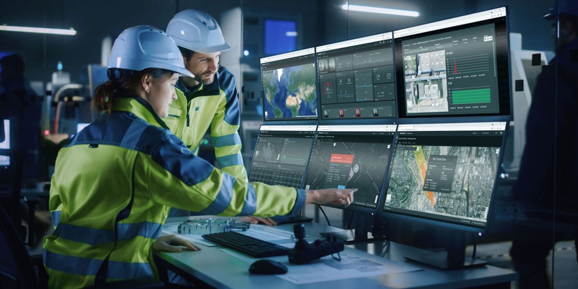 Industry 4.0 Modern Factory: Project Engineer Talks to Female Operator who Controls Facility Production Line, Uses Computer with Screens Showing AI, Machine Learning Enhanced Assembly Process