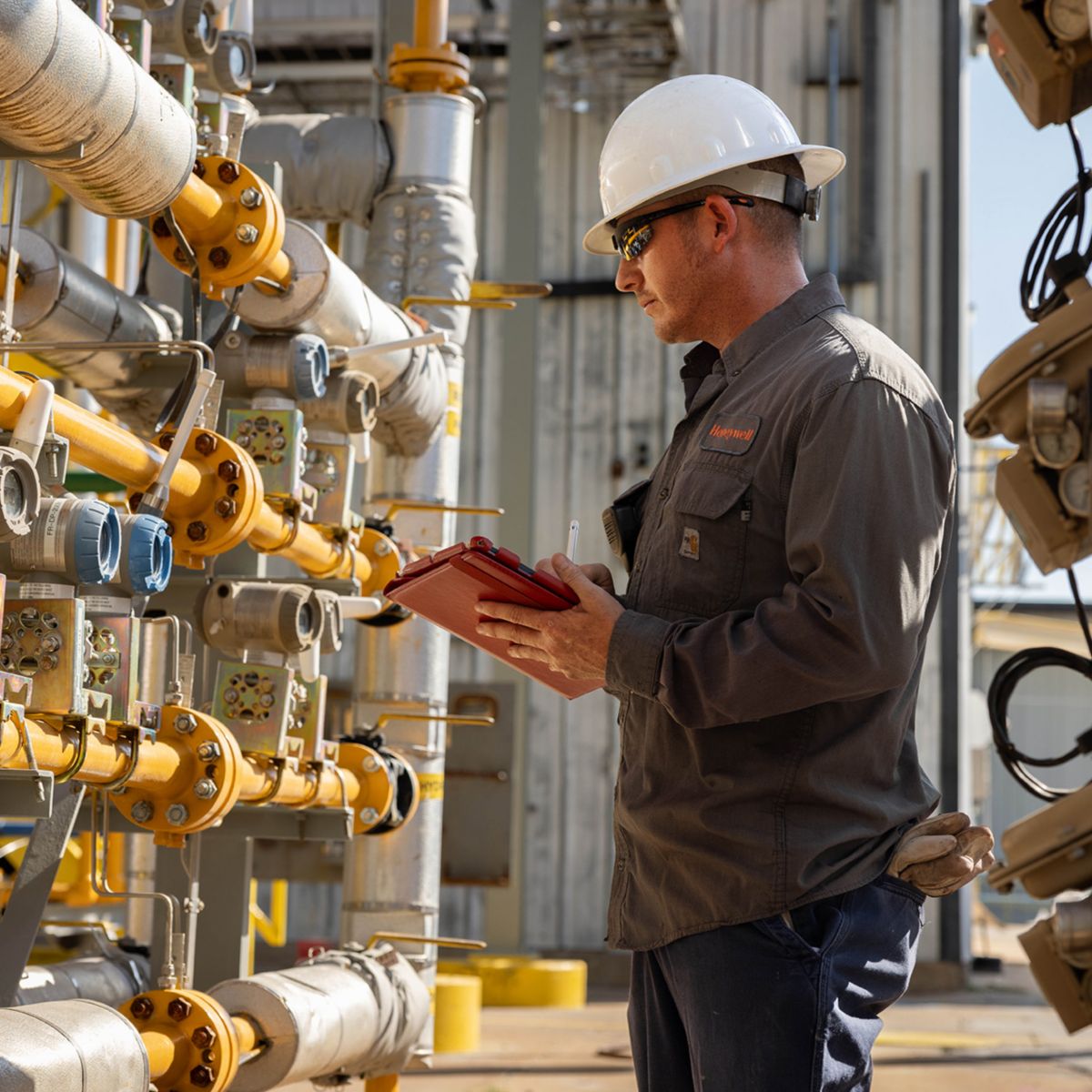 Technician inspecting flow sensors and transmitters on industrial piping, ensuring accurate measurement, system reliability, and optimized process performance.