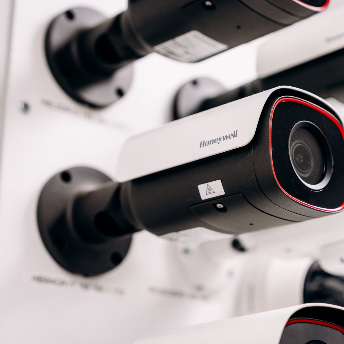 A close-up shot of professional Honeywell surveillance cameras mounted on a display board for corporate industrial monitoring solutions.