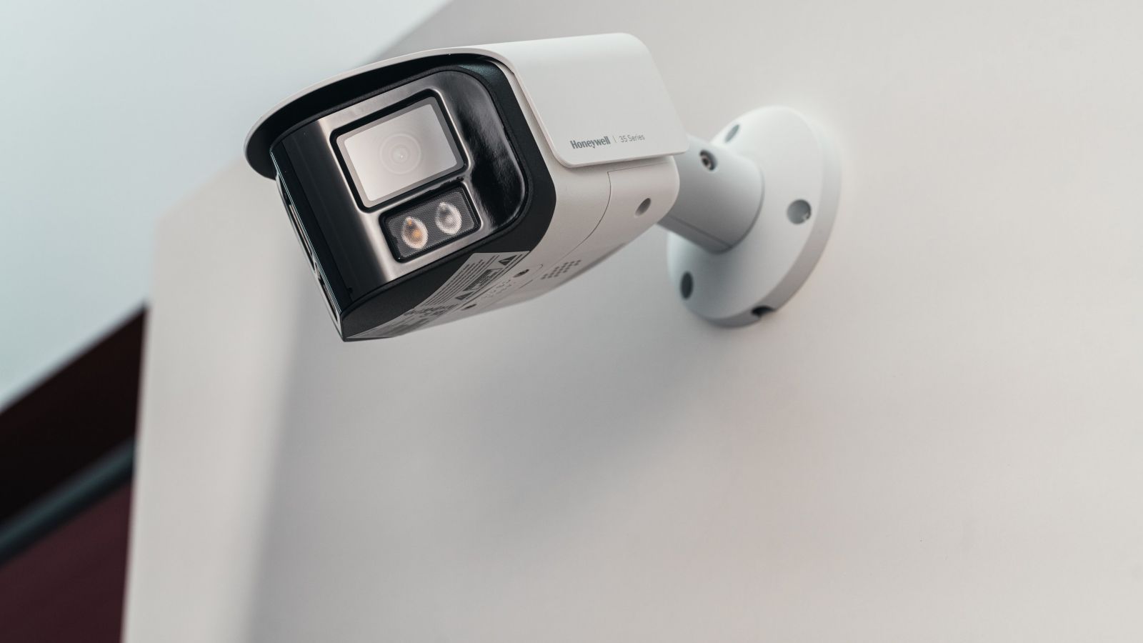 Outdoor security camera mounted on a wall with built-in lens and dual lights