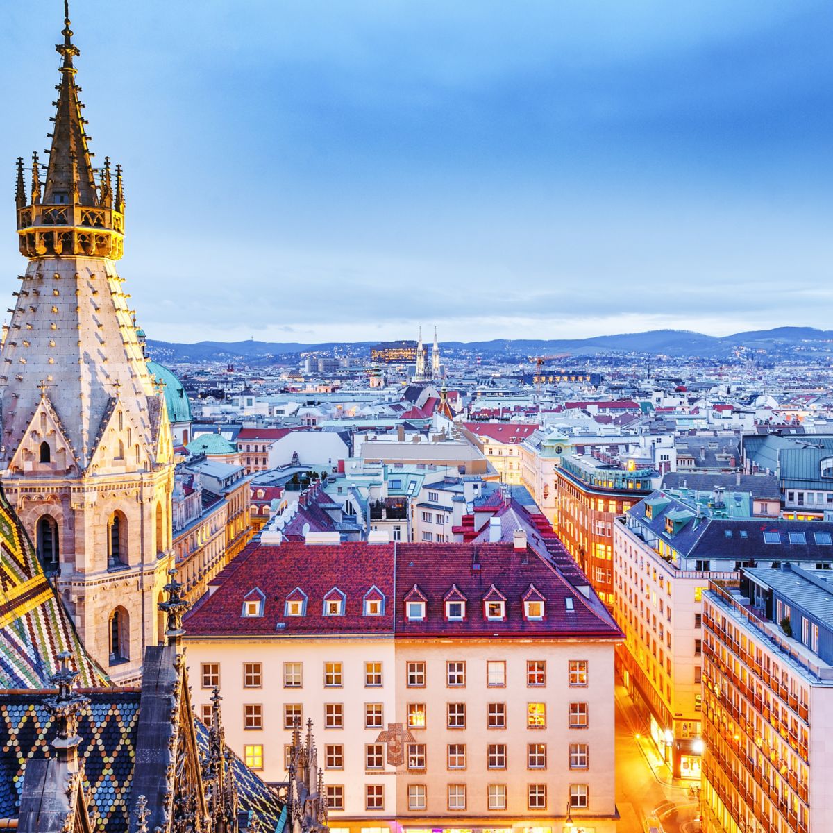 Vienna, Austria, Europe. Lovely twilight skyline view from above of Vienna. Iconic landmark and extremely popular European travel destination. View over roofs on classic architecture, dusk scenery.