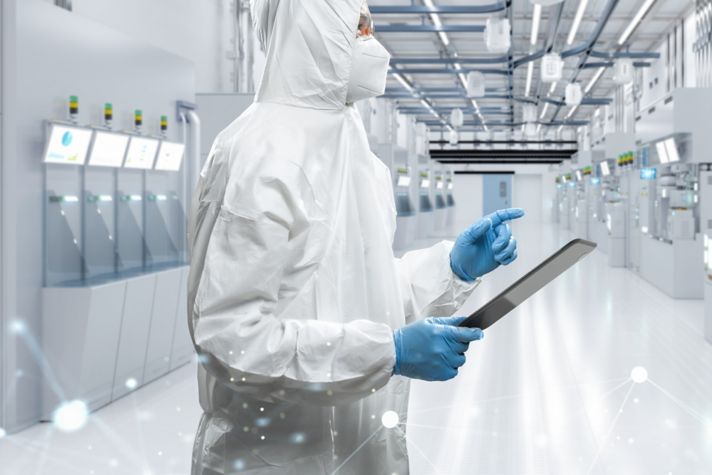 Worker or engineer wears protective suit or white coverall suit work in semiconductor manufacturing factory