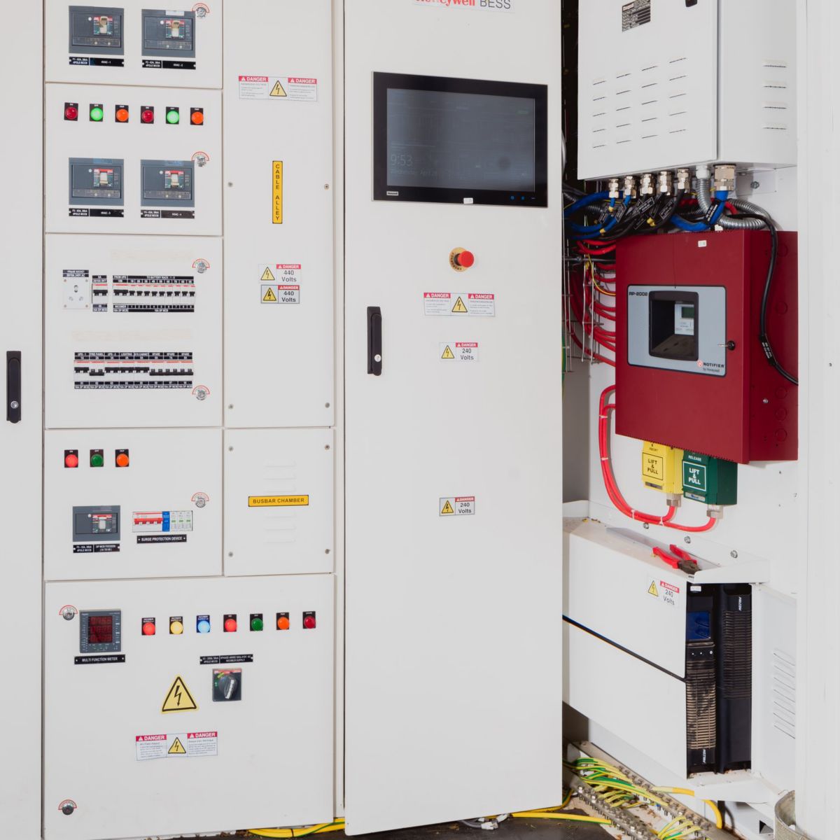 A Honeywell Battery Energy Storage System cabinet featuring integrated control panels, circuit breakers, and safety indicators in an industrial setting.