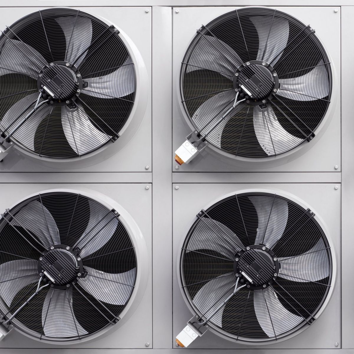 A geometric, straight-on view of multiple industrial HVAC cooling fans mounted in a symmetrical grid pattern for climate control.