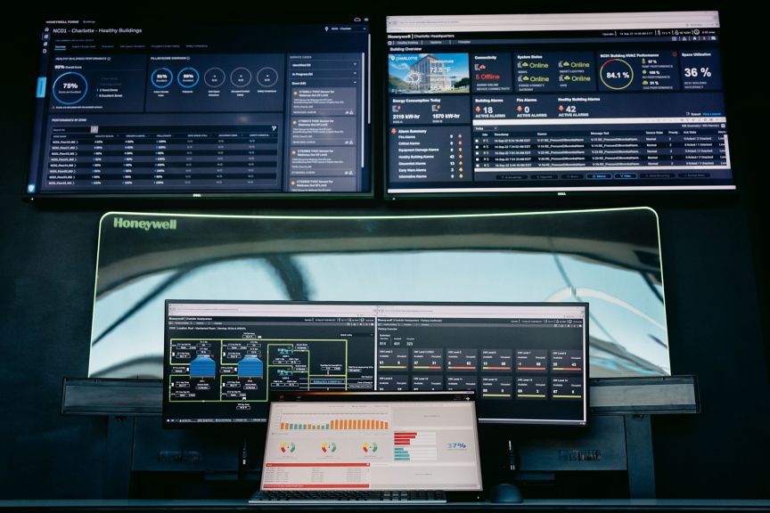 Multiple screens display real-time data analytics and performance metrics for a smart building management system.
