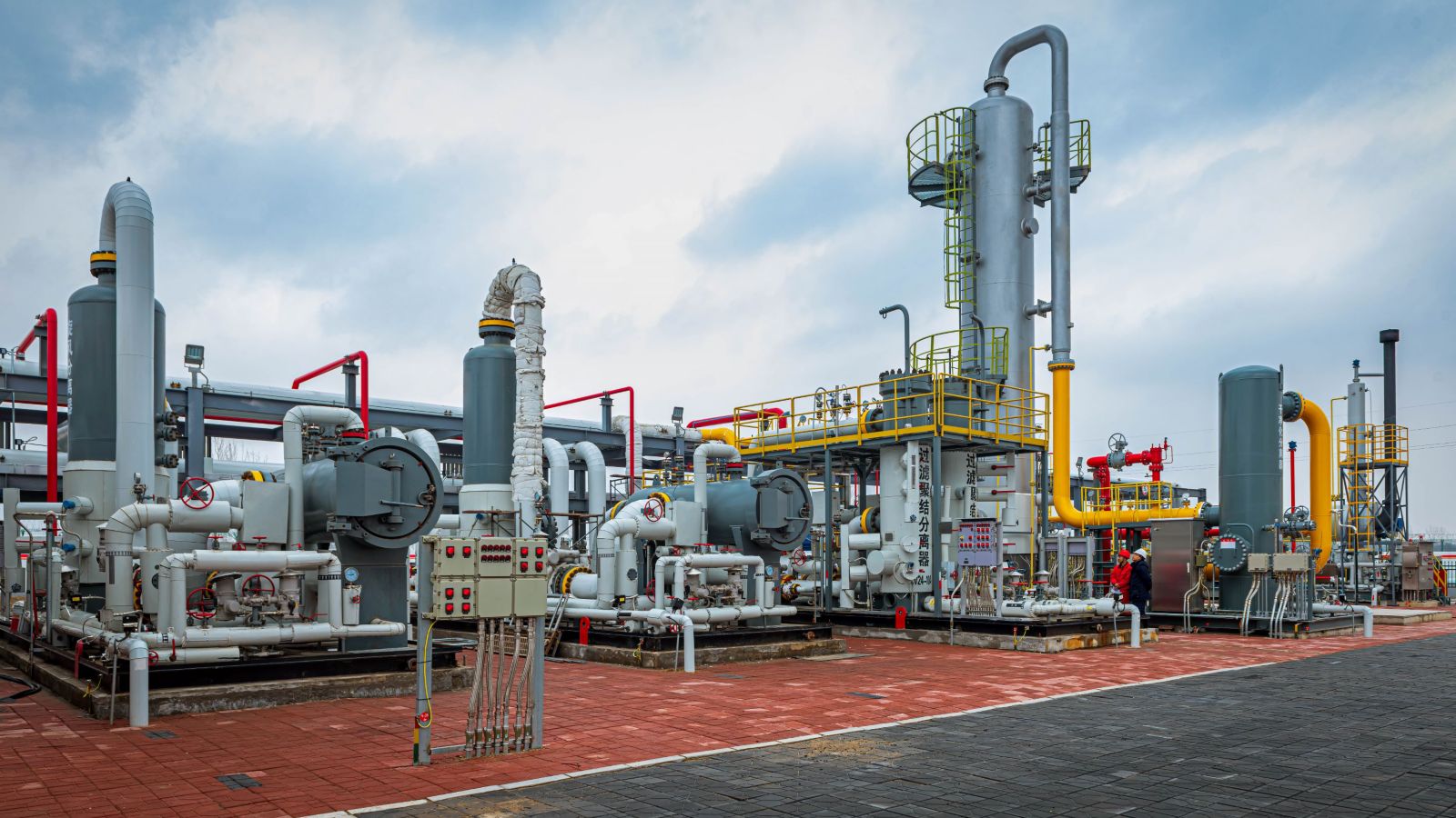 Detailed view of machinery and pipelines at a gas processing plant, showcasing industrial operations.
