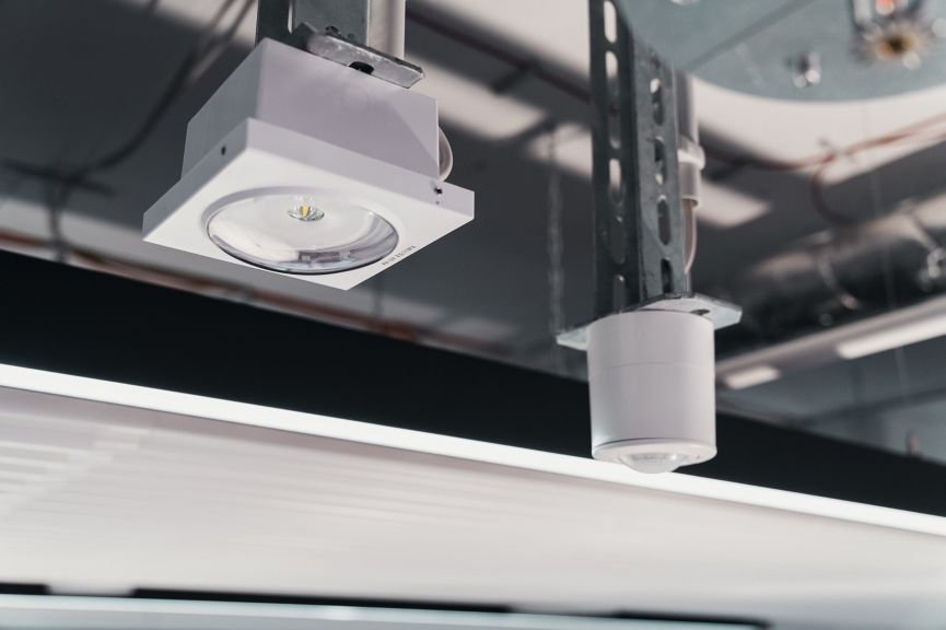 Modern ceiling-mounted LED spotlight and sensor system installed in an industrial facility.