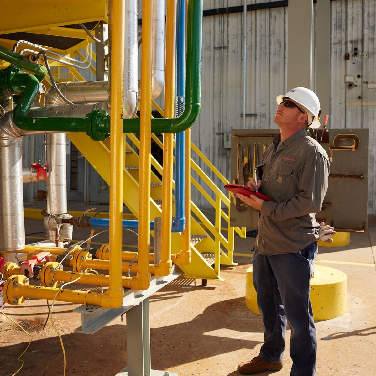 Technician inspecting industrial piping systems, supporting flow monitoring, operational efficiency, and reliable process performance in complex environments.
