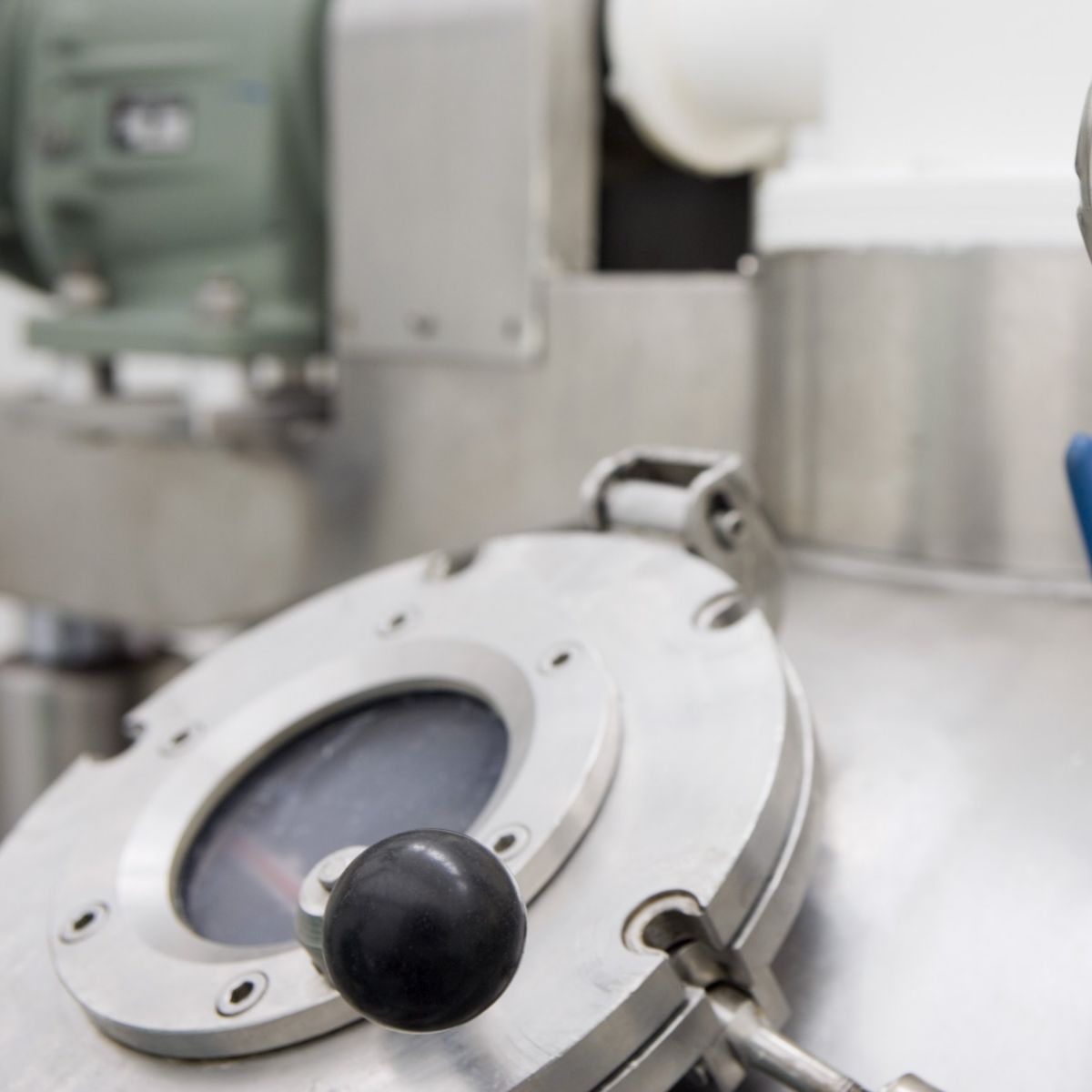 Close-up of a pressure gauge on industrial equipment showing kPa readings, connected to stainless steel piping and valves