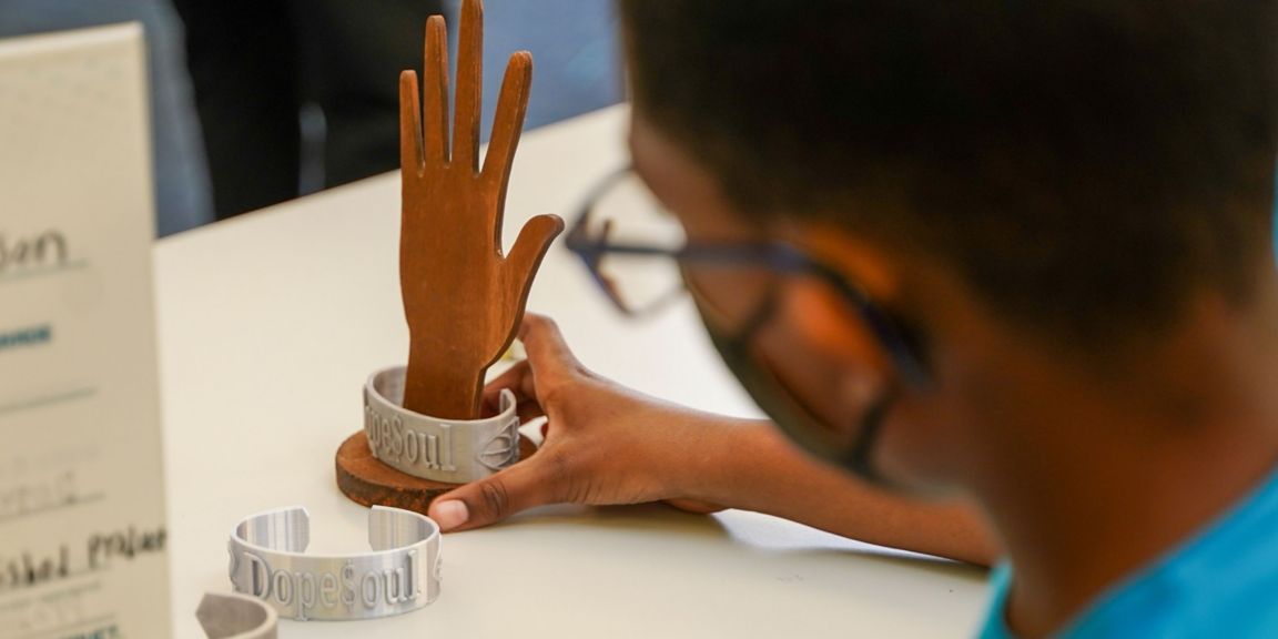A student holds a 3D-printed cuff bracelet.