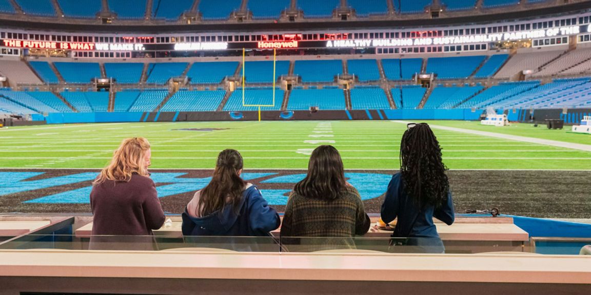 Four people sit on the field level of Bank of America Stadium in Charlotte, North Carolina, during an activity for the Futureshaper Sustainability Challenge