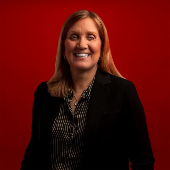 Professional portrait of Karen Mattimore, captured against a bold red background.