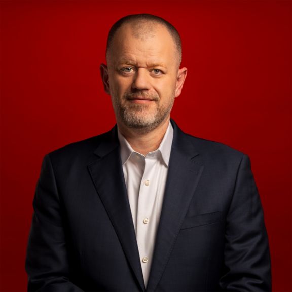 Corporate portrait of Mike Stepniak with a bold red backdrop