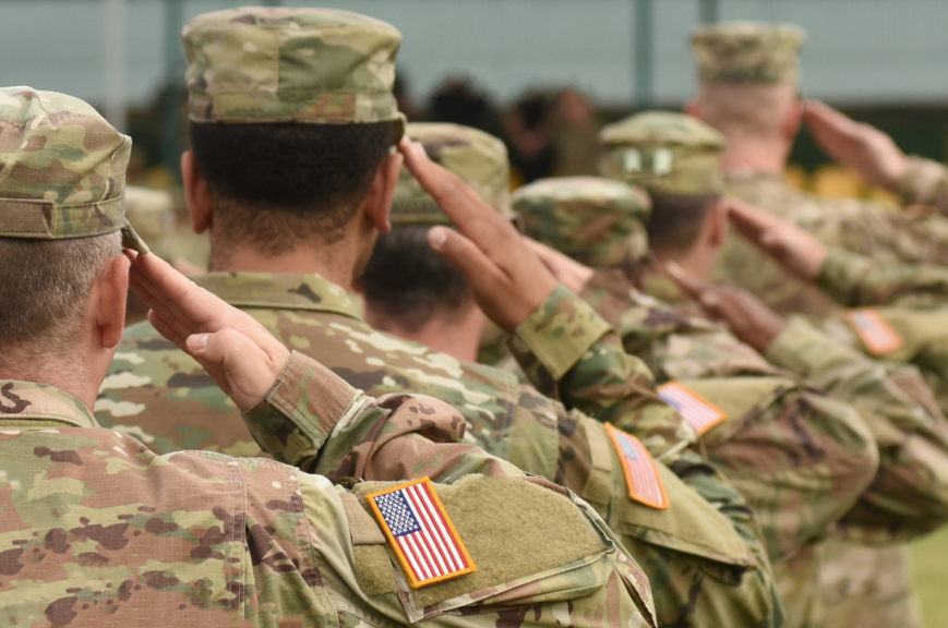 Soldiers in uniform salute during a ceremony, showcasing their commitment and respect for military traditions.