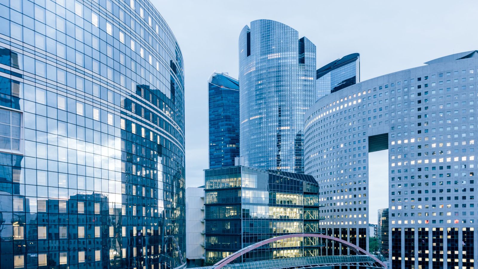 Stunning close-up of sleek modern skyscrapers with reflective glass facades in an urban landscape, capturing evening light.