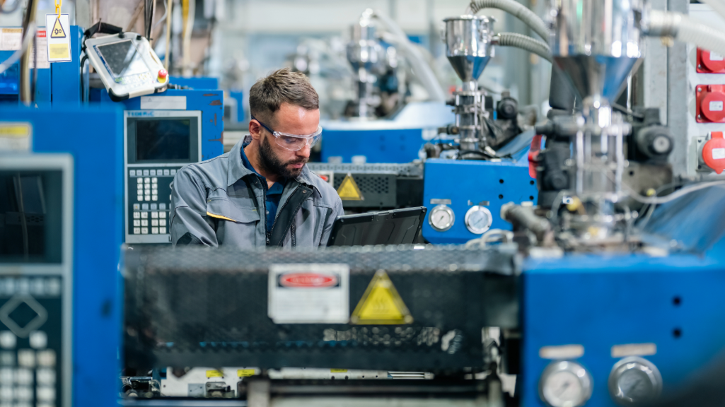 Worker monitoring machinery along automated production line.