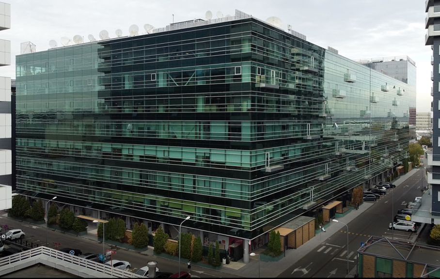 Sleek modern office HQ in Romania with glass facade, urban setting, and contemporary architecture—ideal for corporate and tech businesses.