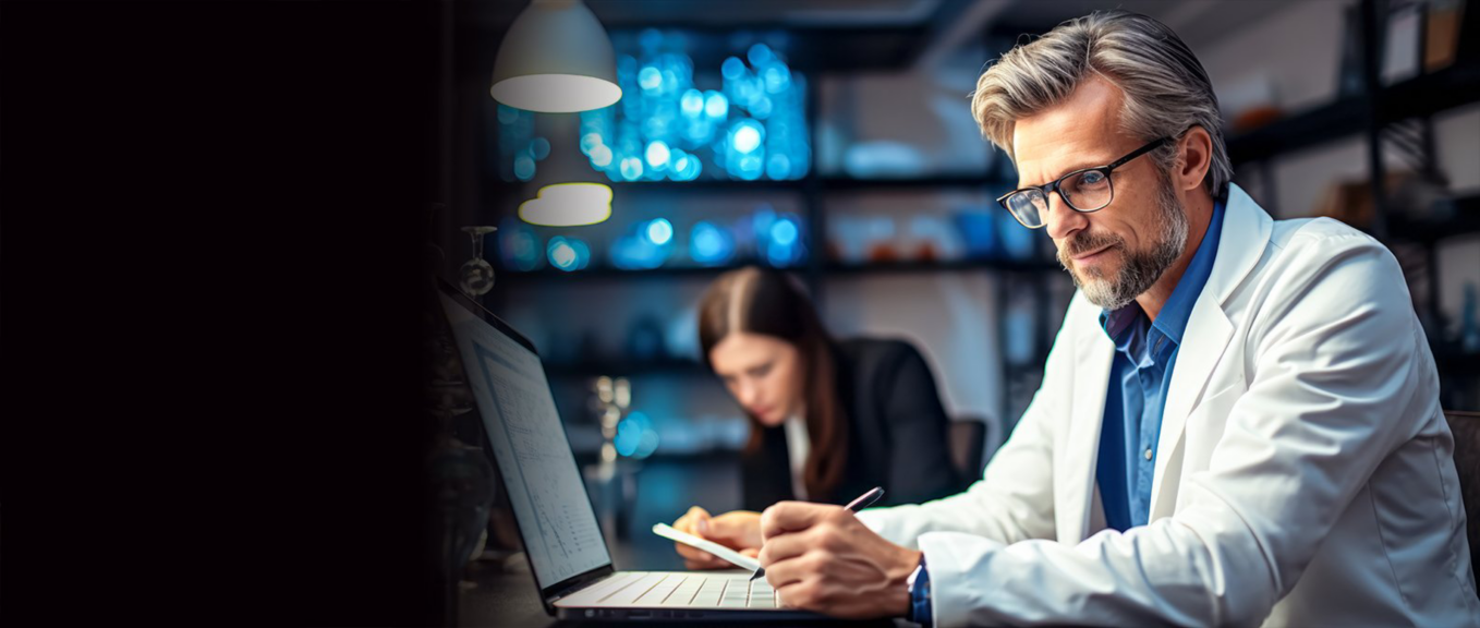 A male scientist in a white coat reviews a tablet in a dark laboratory with blue lights.