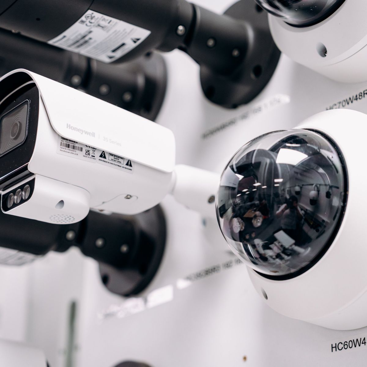 A selection of professional Honeywell security cameras mounted on a wall for display and demonstration purposes.