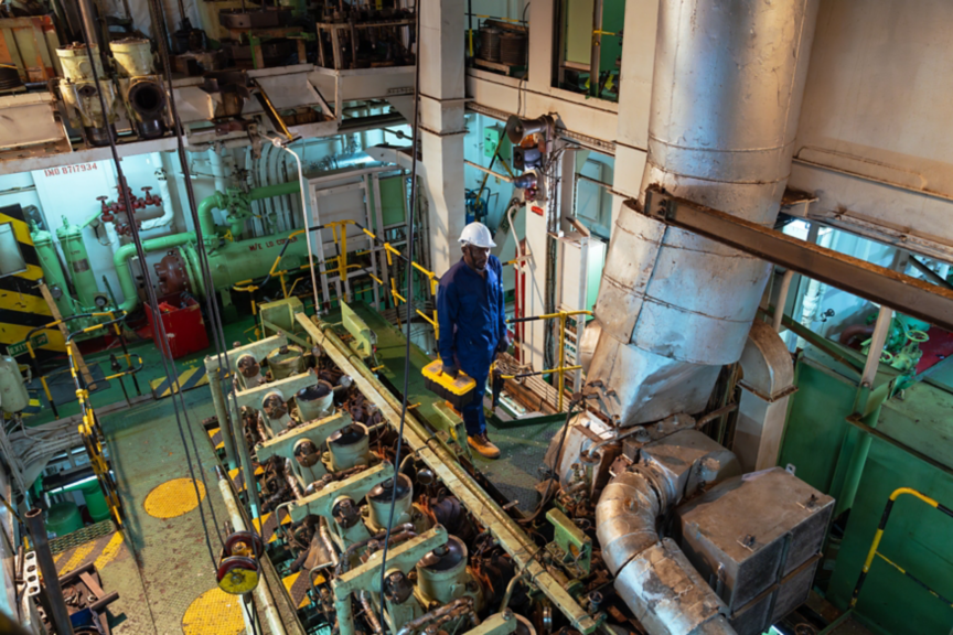 Portrait of a ship worker is walking in the ship's engine room