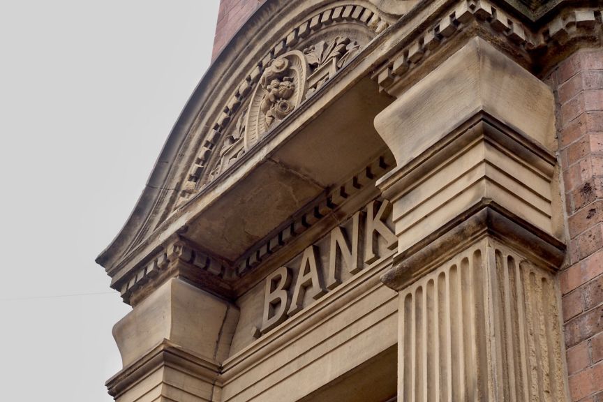 Historic bank building entrance with carved stone details, decorative architecture, and visible bank signage representing traditional financial institutions.