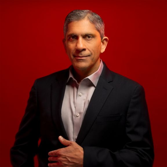 Professional bio image of Vimal Kapur, CEO of Honeywell, against a bold red background