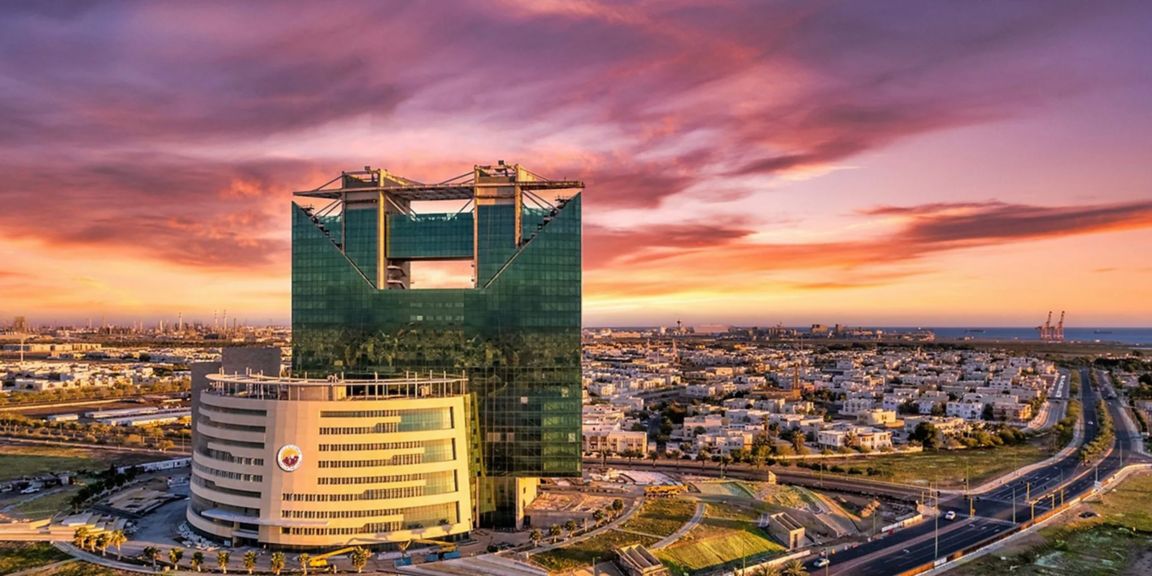 Aerial view of Yanbu industrial city with modern architecture and warm sunset sky.