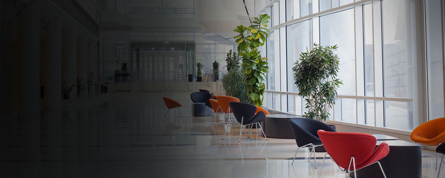 Coworkers walking and using bicycle on office's lobby - with face mask