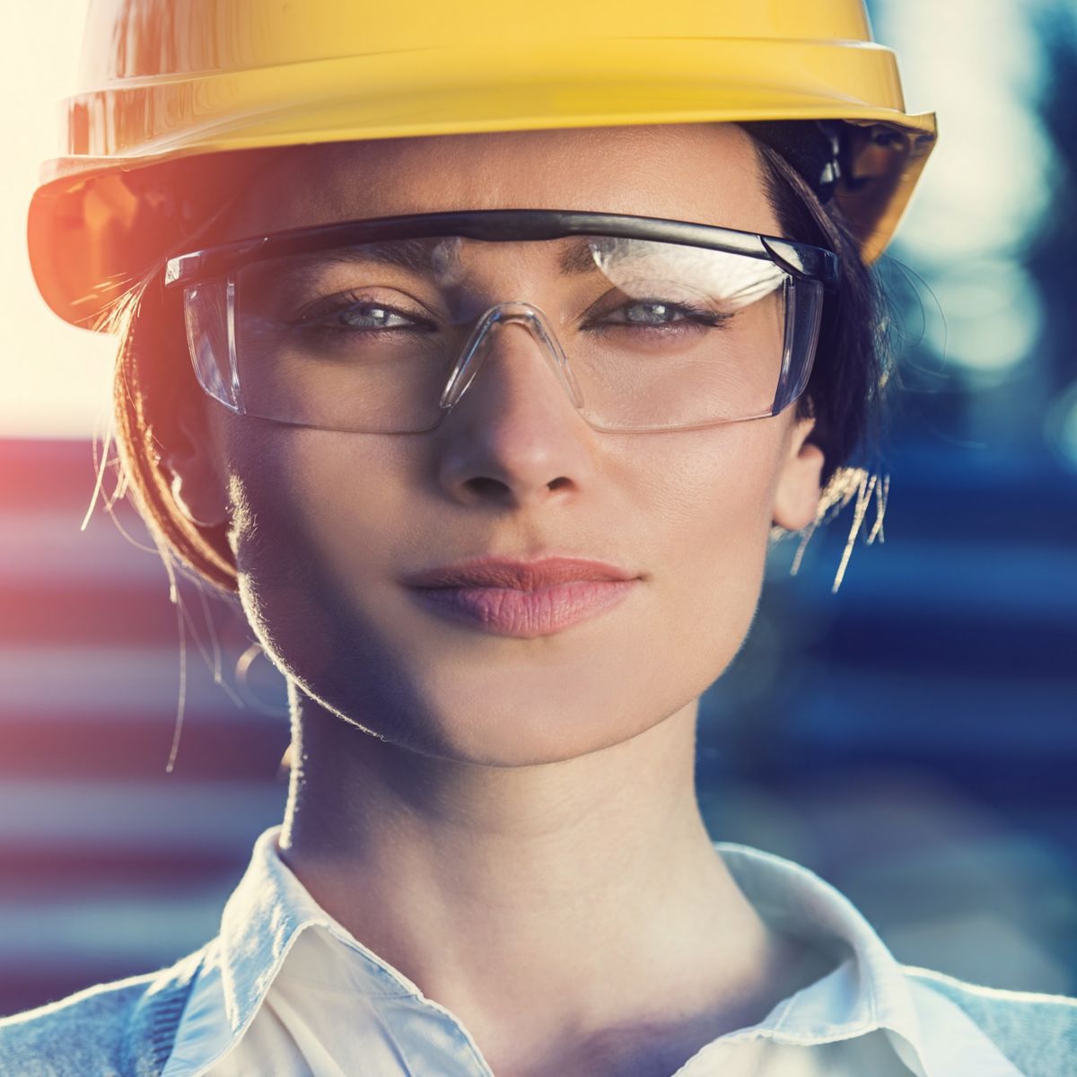 beautiful woman civil engineer or architect with yellow protective industrial helmet and protective glasses close up