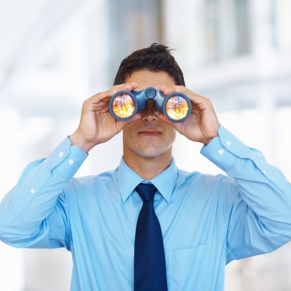 Portrait of young business man seeking through binoculars