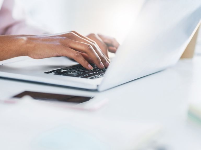 Closeup shot of an unrecognizable woman working on a laptop in an office