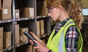 woman using a mobile device in front of shelves