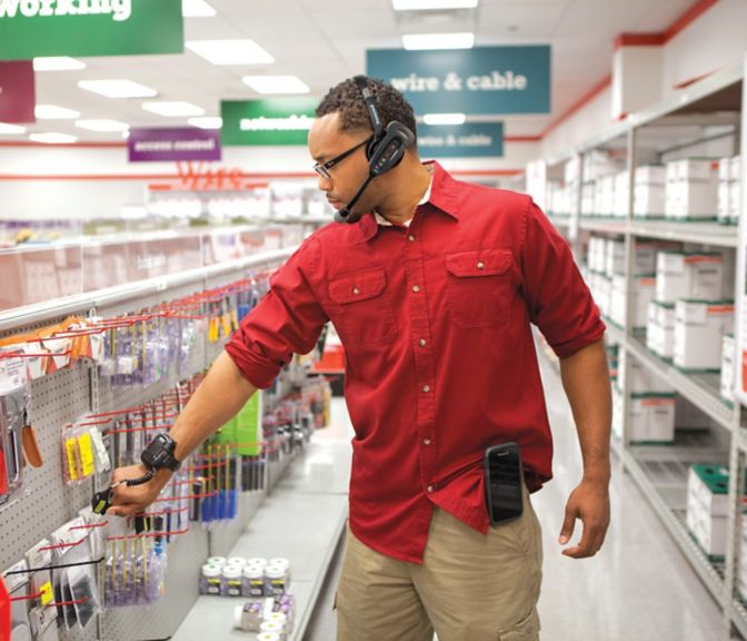 worker using a wearable scanner to scan a customer’s product 