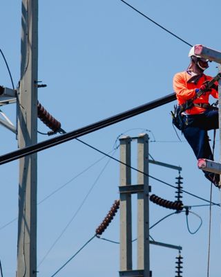 Electricians are climbing on electric poles to install and repair power lines.