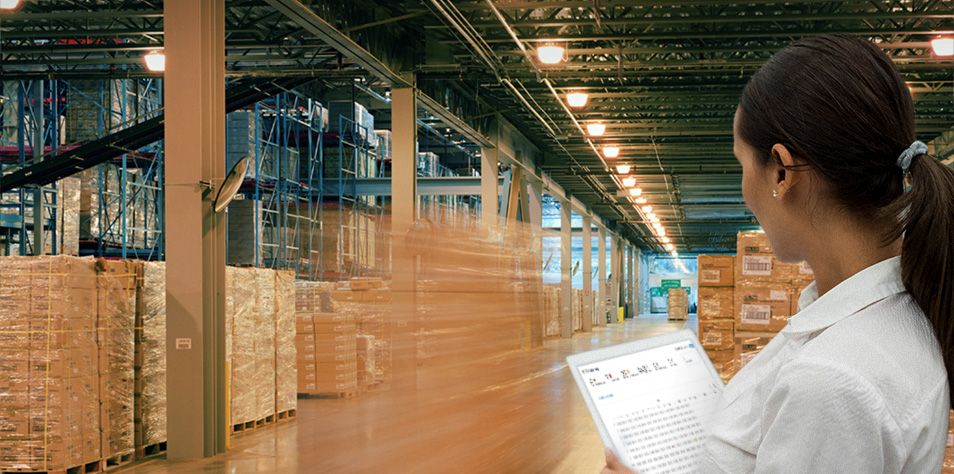 Woman in warehouse reviewing data