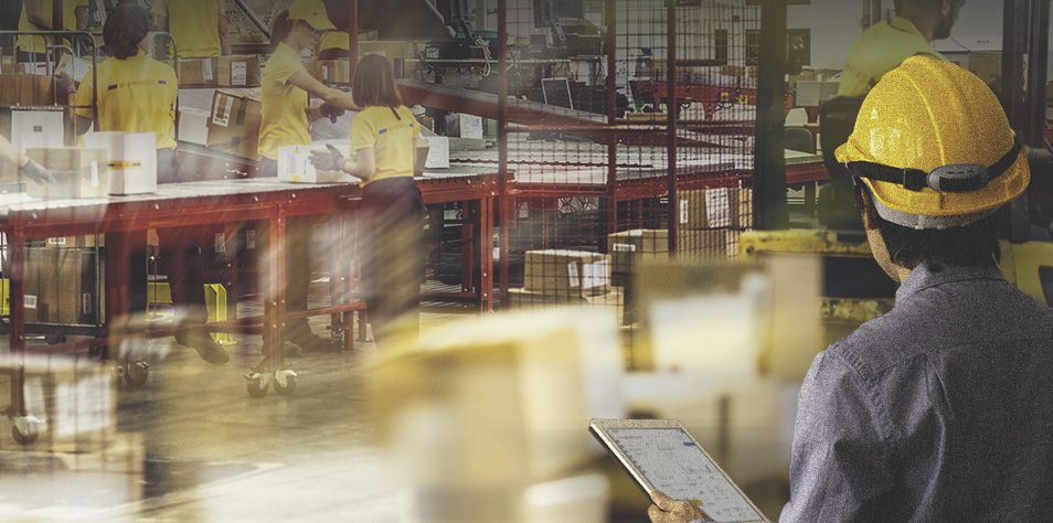 Man overlooking material handling equipment in a distribution center