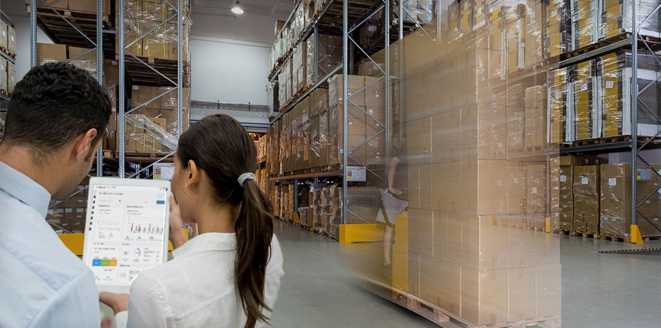 Man and woman reviewing data in a warehouse