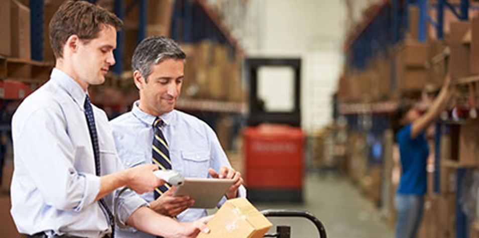 Two men using tablet in a warehouse