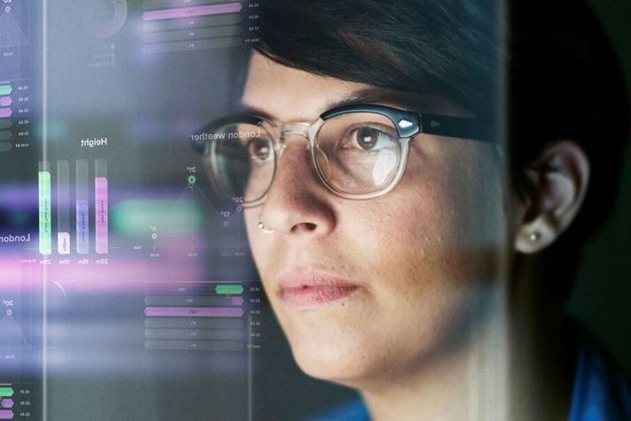 woman looking at data on monitors