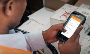 hands holding mobile device over some boxes