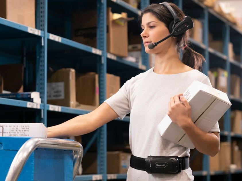 woman wearing headset in front of shelves