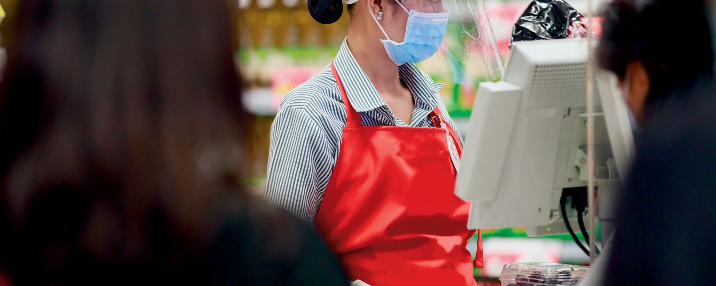 retail checkout assistant wearing safety equipment