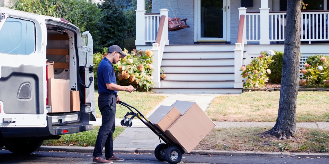 Courier delivering a package in front of a house