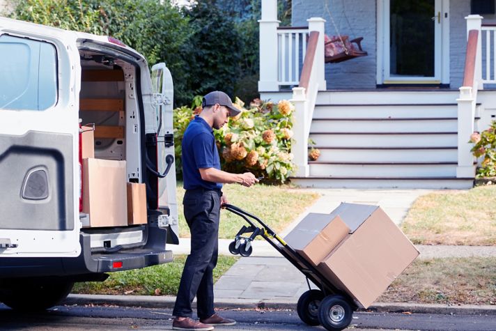 Courier delivering a package in front of a house