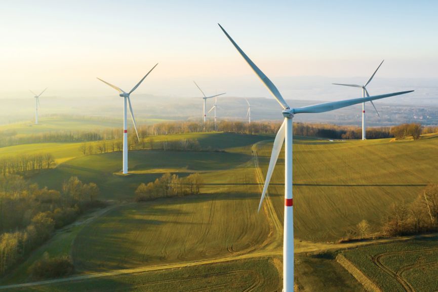 Panoramic view of wind farm or wind park, with high wind turbines for generation electricity with copy space. Green energy concept.
