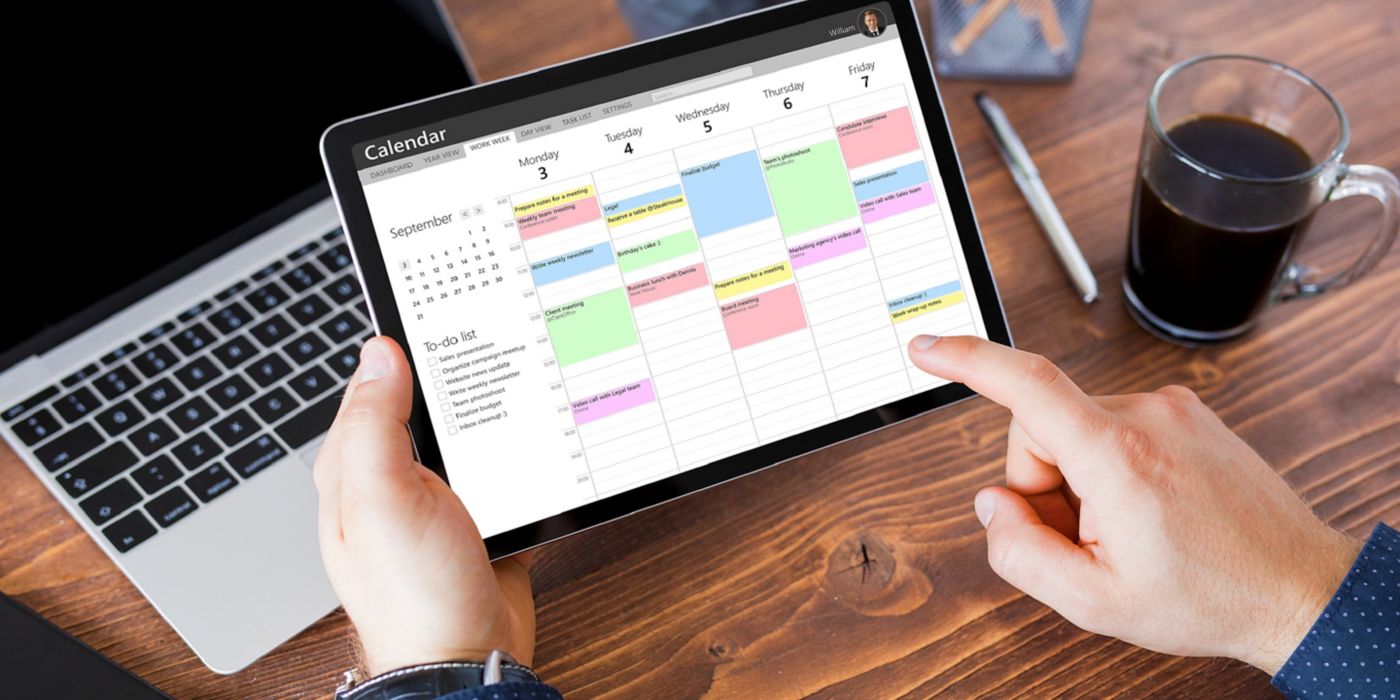 Man using calendar app on tablet in office