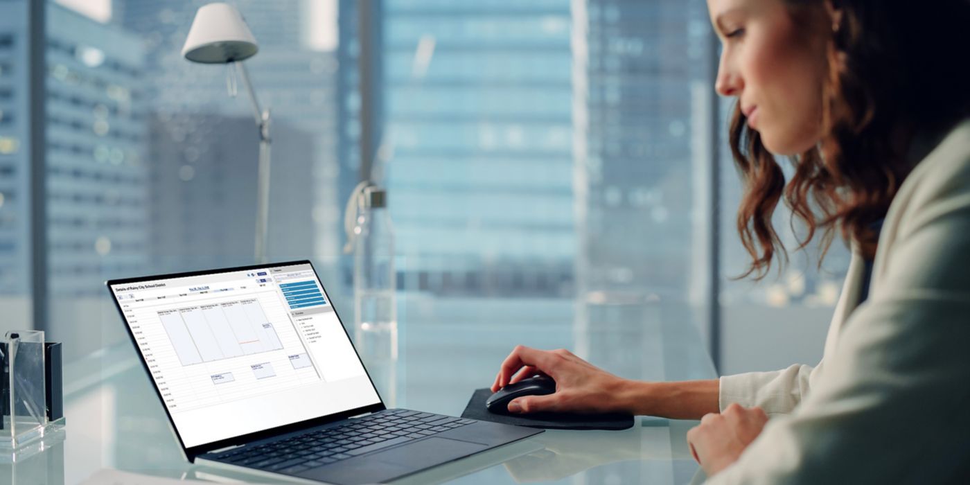 A lady with the laptop sitting in a conference room