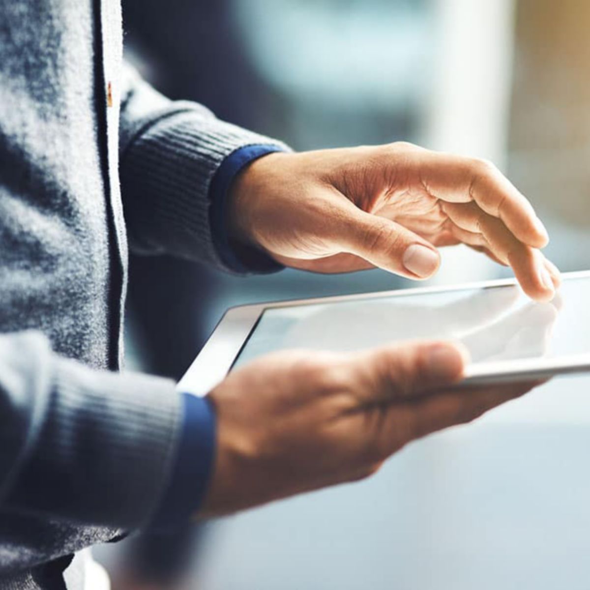 Closeup shot of an unrecognisable businessman using a digital tablet in an office