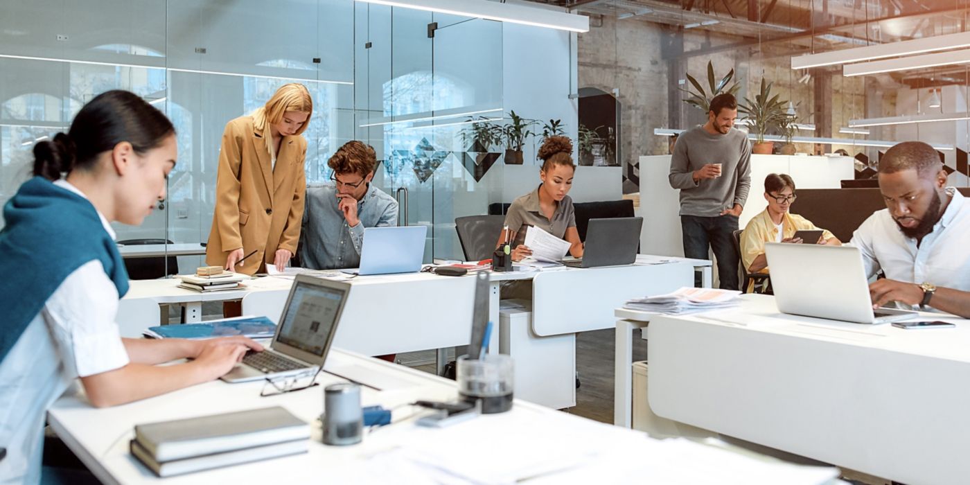 Employees in meeting, sitting at conference room table.