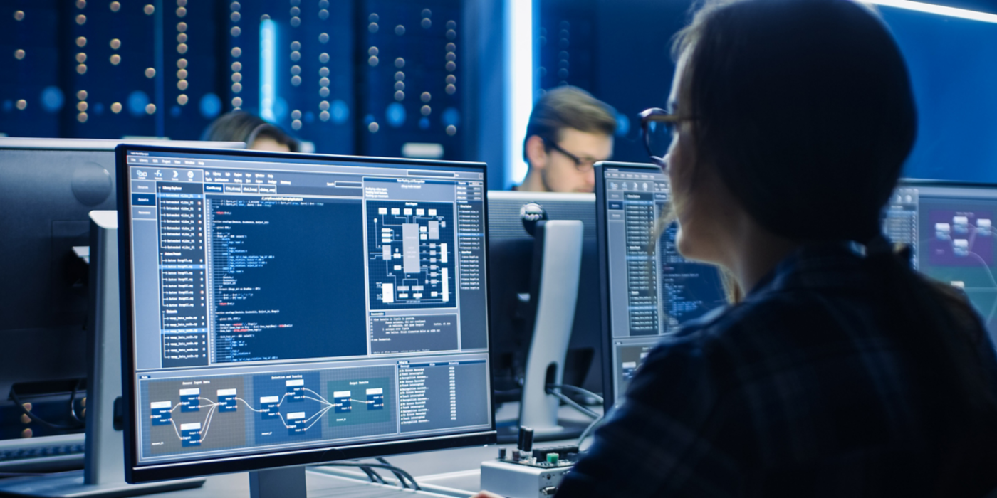 Smart Female IT Programer Working on Desktop Computer in Data Center System Control Room. Team of Young Professionals Doing Code Programming
